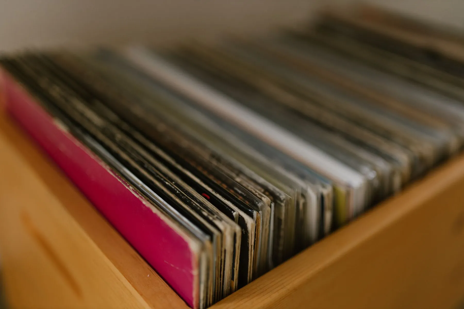 A wooden crate packed with vinyl records.