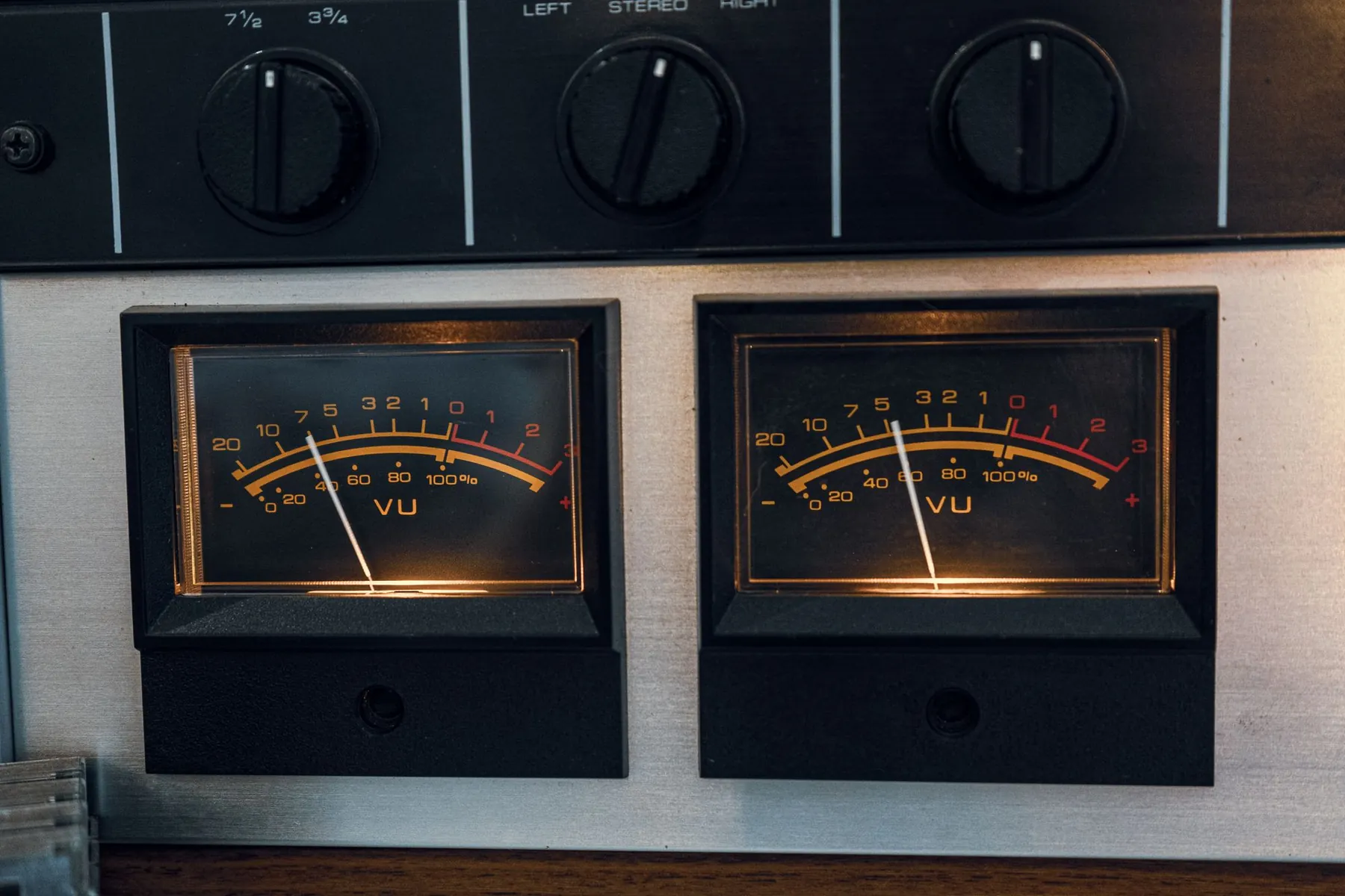 Two glowing VU meters on vintage audio equipment.